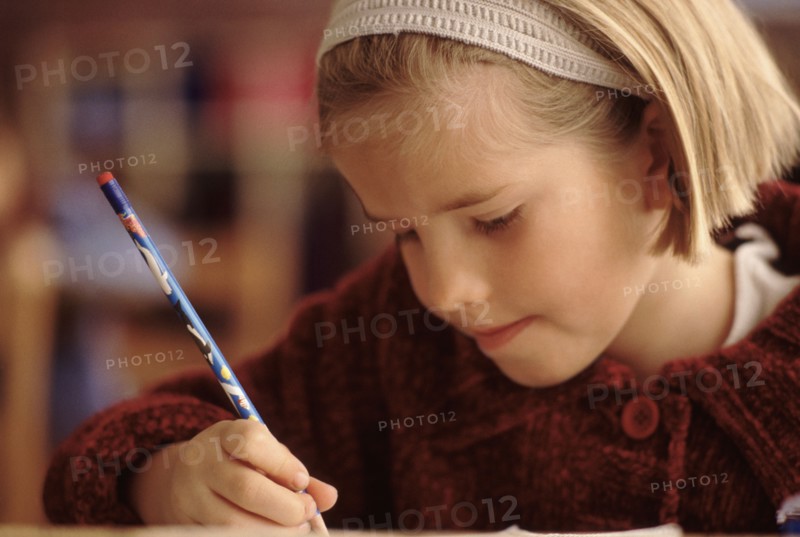 Elementary school student writing with a pencil. Photo : Rob Lewine
