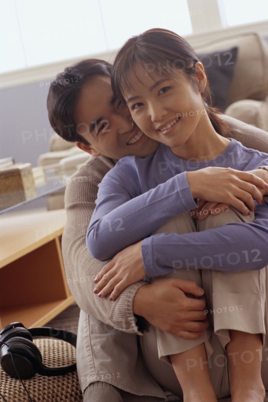 Happy couple sitting together on the floor in their home. Photo : Rob Lewine