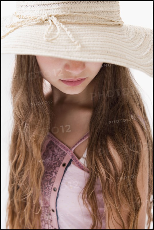 Long haired woman wearing a straw hat that covers her eyes. Photo : Mike Kemp