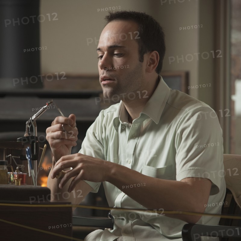 Man repairing fly fishing hook. Photo : Mike Kemp