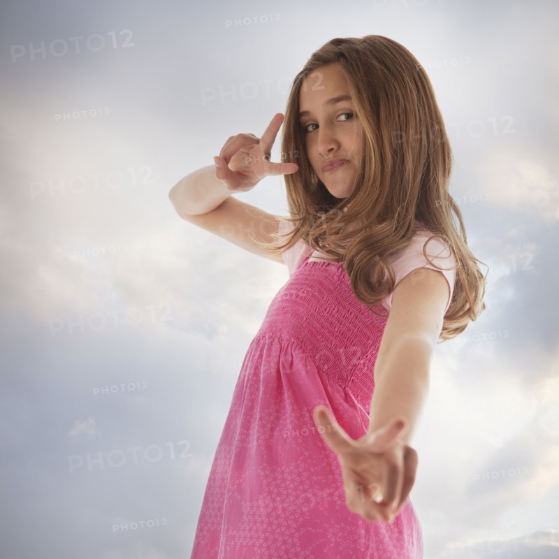 Pretty teenage girl giving peace sign. Photo : Mike Kemp
