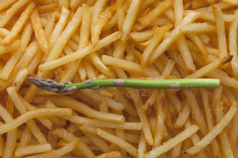 Asparagus spear on top of a pile of French fries. Photo : Mike Kemp