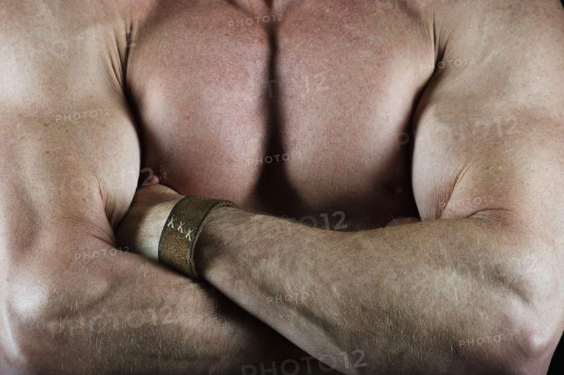 Shirtless muscular man with his arms crossed. Photo : Daniel Grill