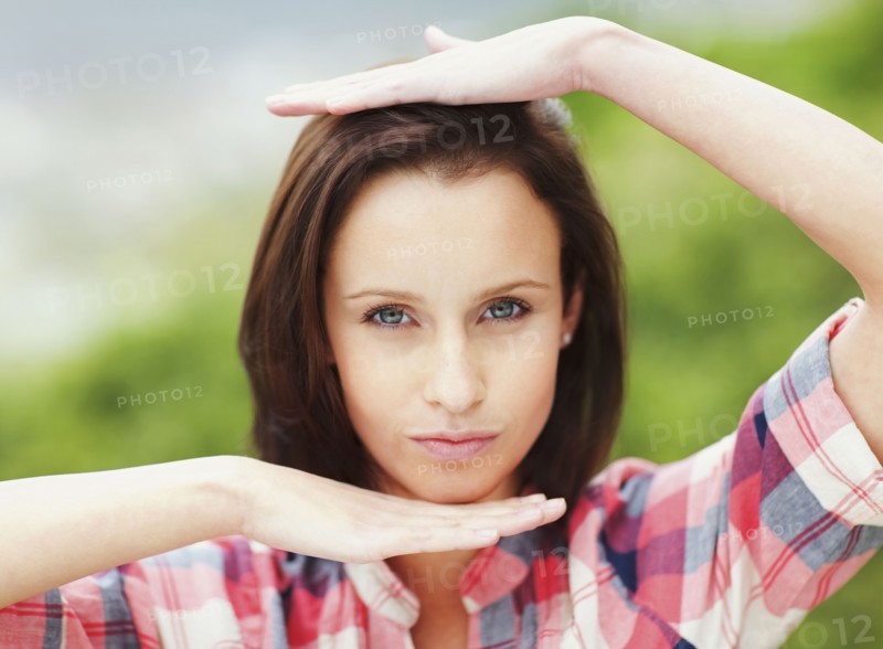 Woman making frame around her head with her hands. Photo : momentimages