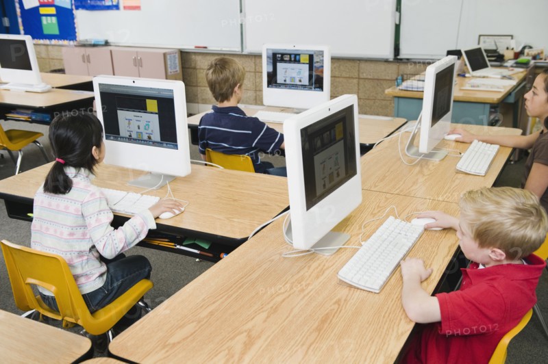 Children working at computers in classroom.