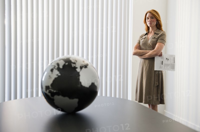Businesswoman looking at globe.