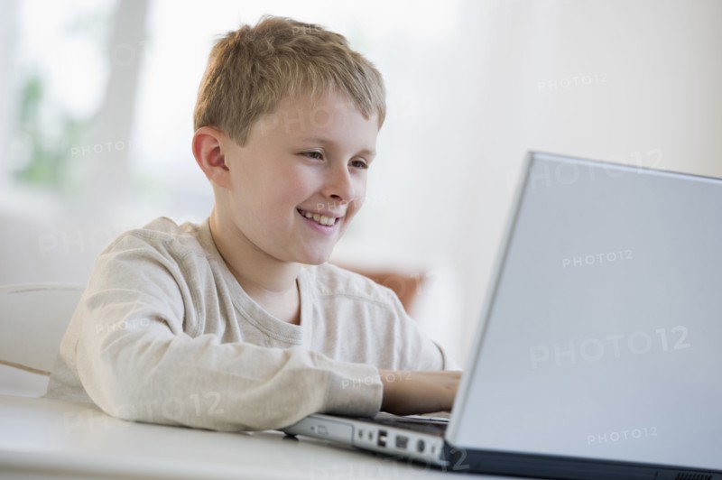Young boy looking at laptop.