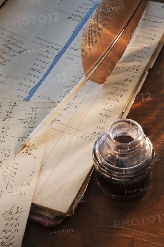 Ink feather pen and ledger.