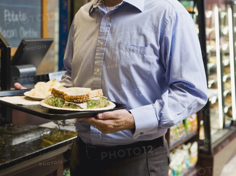 Man carrying sandwich on tray. Photo. Erik Isakson