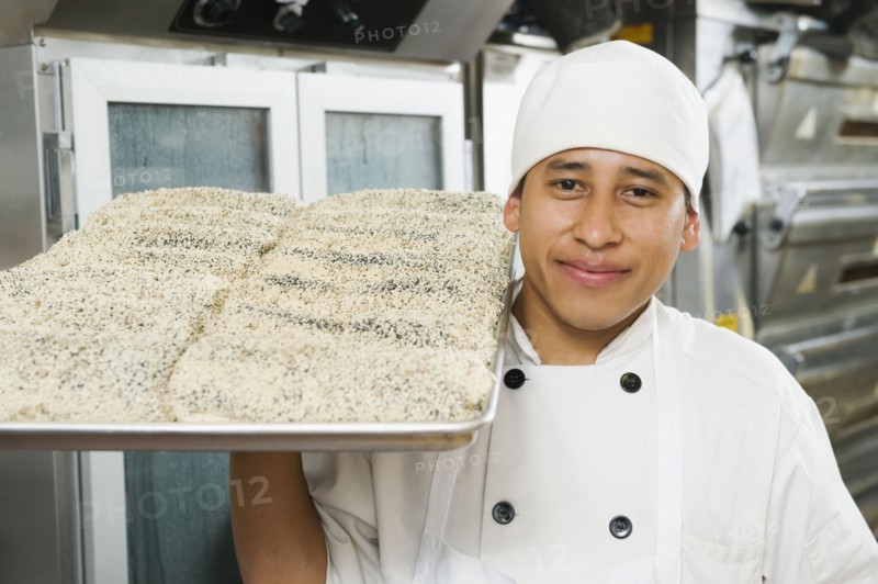 Chef holding tray of bread. Photo. Erik Isakson