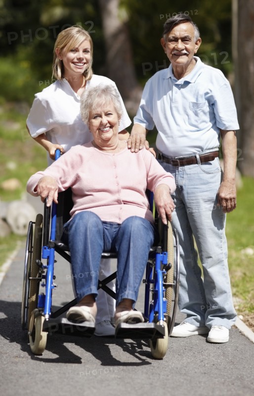 Nurse pushing senior woman in a wheelchair. Photo. momentimages