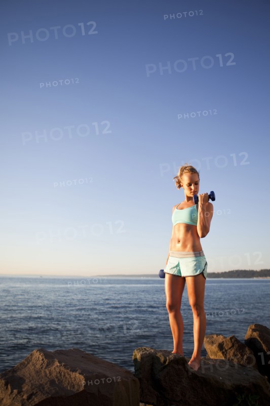 Athletic woman lifting weights outdoors. Photo. Take A Pix Media