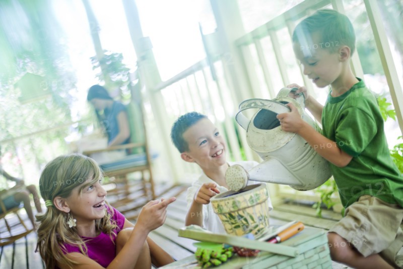 Young children watering seeds in a planter. Photo. Tim Pannell