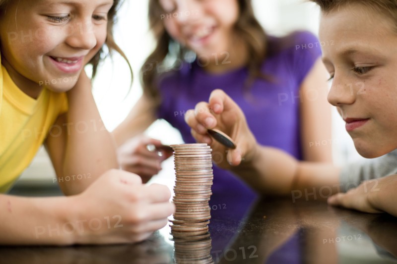 Children stacking coins. Photo. Tim Pannell