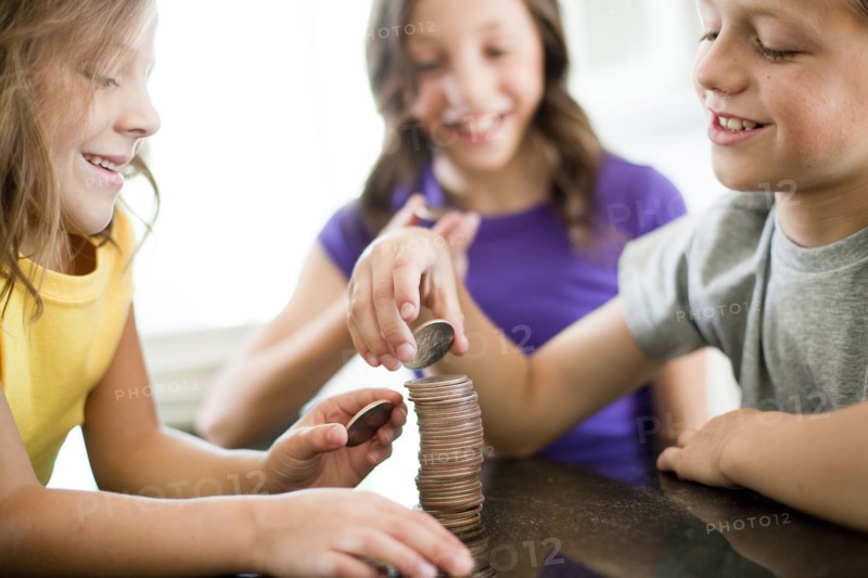 Children stacking coins. Photo. Tim Pannell