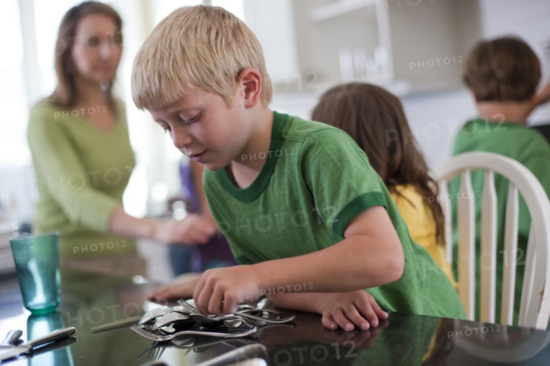 Young boy setting the table. Photo. Tim Pannell