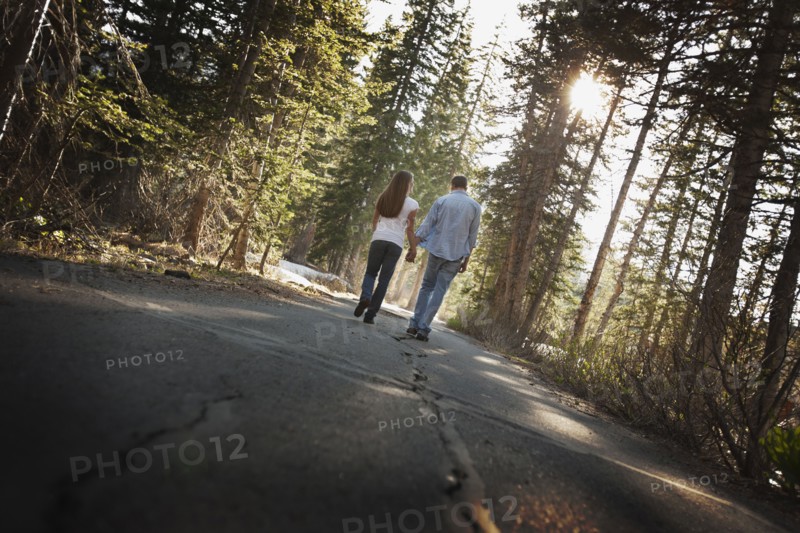 Couple walking hand in hand on a country road. Photo. FBP
