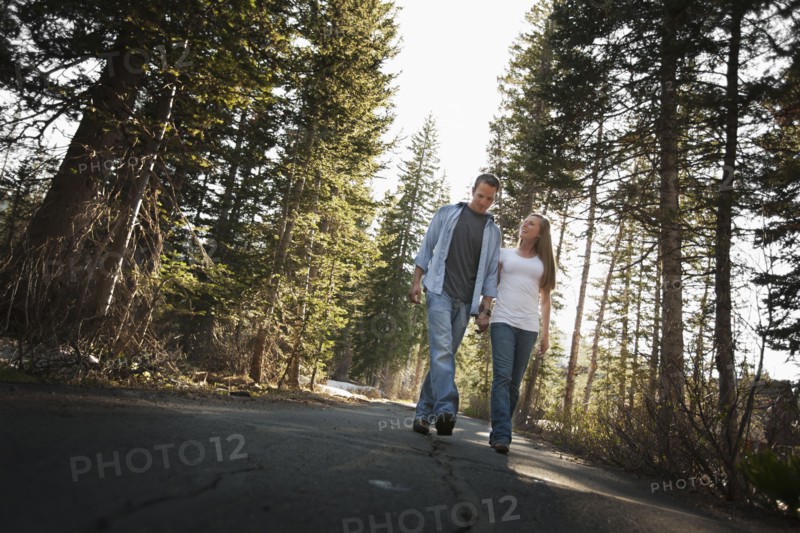 Couple walking hand in hand on a country road. Photo. FBP