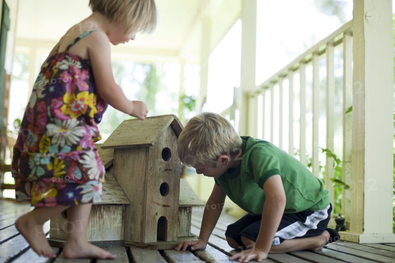 Brother and sister looking at birdhouse. Photo. Tim Pannell