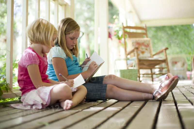 Two girls writing letters. Photo. Tim Pannell