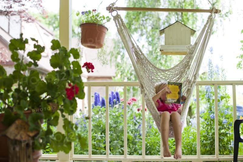 Young girl reading in hammock. Photo : Tim Pannell