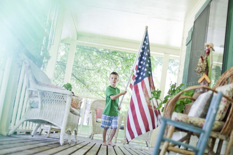 Young boy carrying American flag. Photo. Tim Pannell