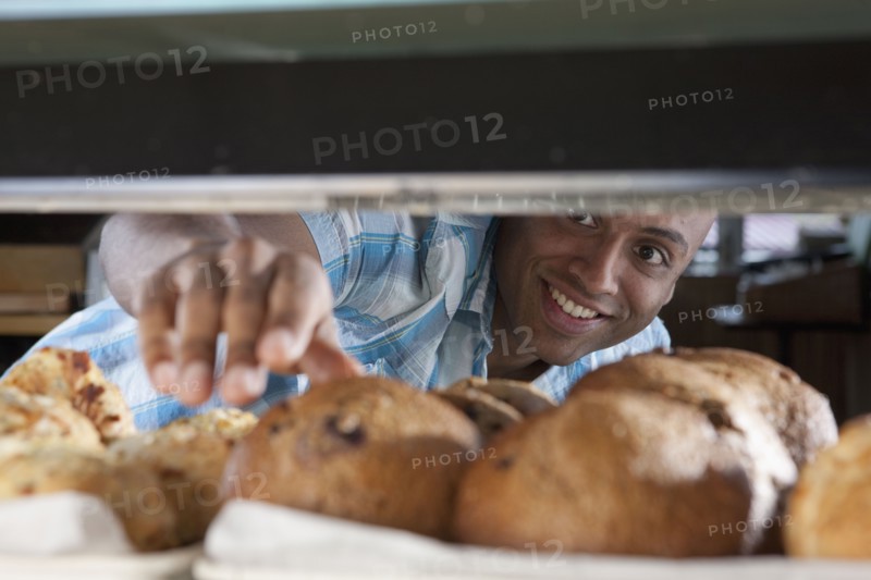 Man reaching for muffin in bakery. Photo. Dan Bannister