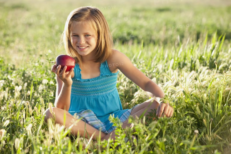 Young girl eating an apple. Photo : Mike Kemp
