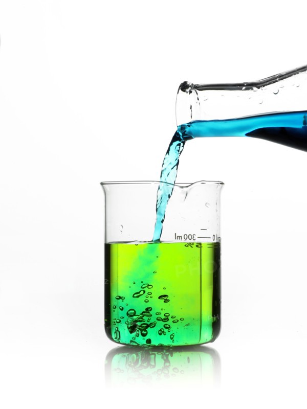 Blue liquid being poured into measuring cup. Photo. David Arky