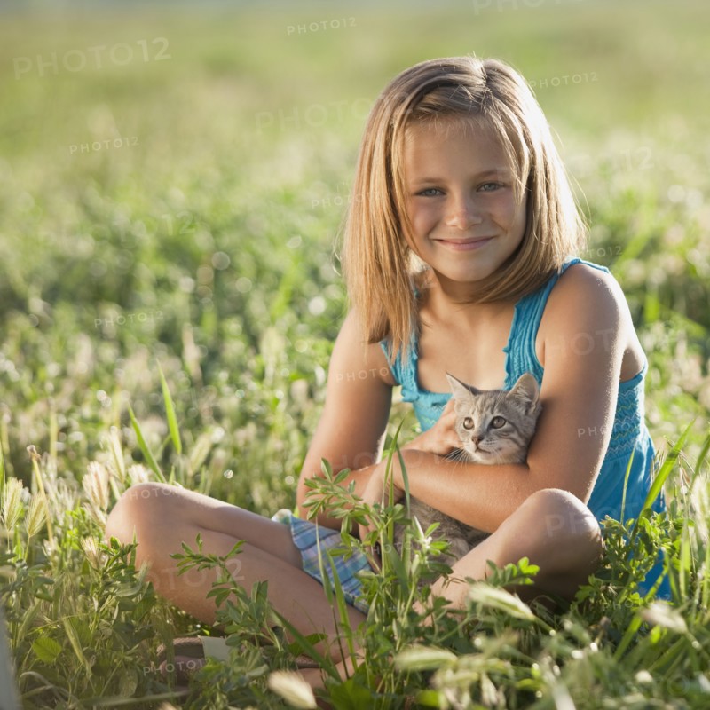 Young girl holding a kitten. Photo. Mike Kemp