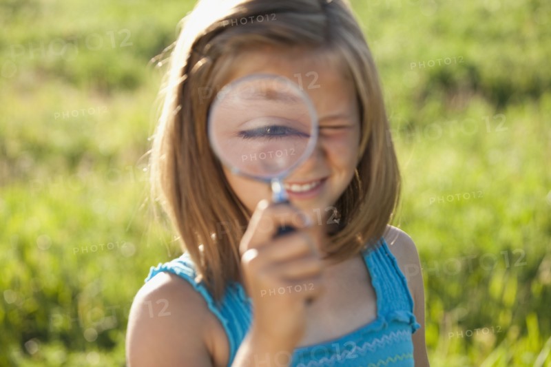 Young girl holding a magnifying glass. Photo. Mike Kemp