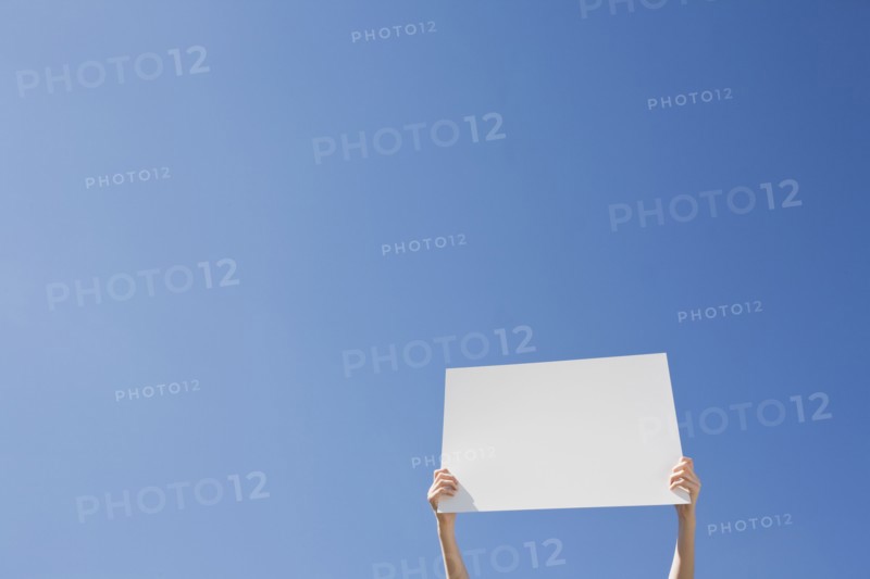 Arms holding a blank placard. Photo. Chris Hackett
