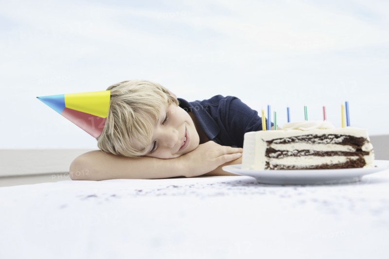 Young boy daydreaming about birthday cake. Photo. momentimages