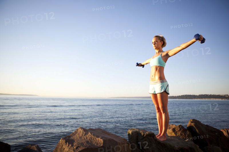 Athletic woman lifting weights outdoors. Photo. Take A Pix Media