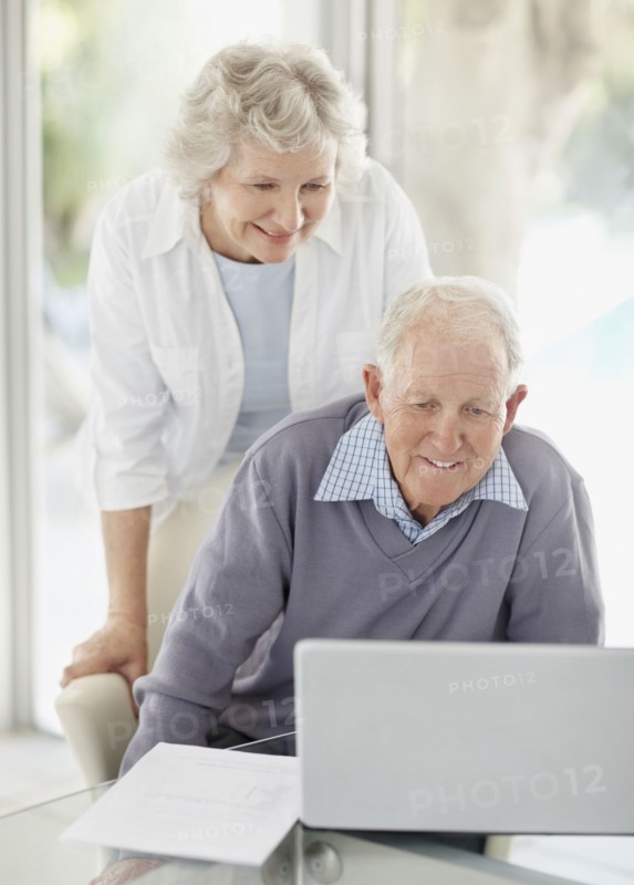 Senior couple browsing the internet together. Photo : momentimages