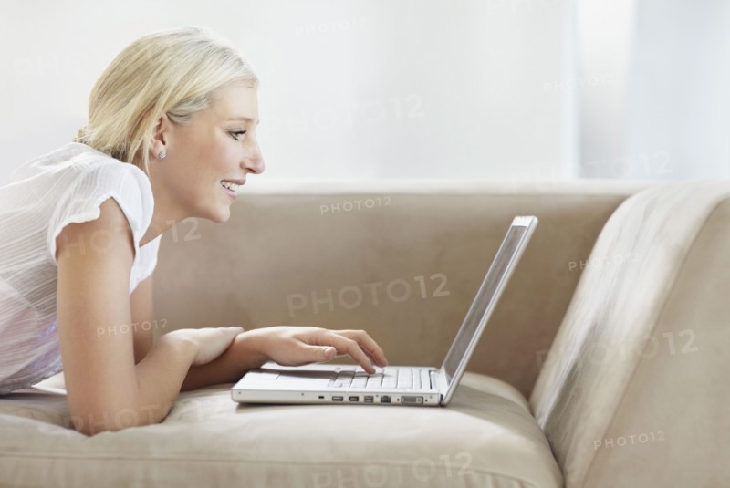 Pretty blond woman browsing the internet. Photo. momentimages