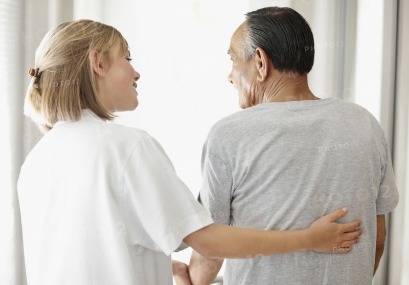Nurse assisting patient with a walker. Photo. momentimages