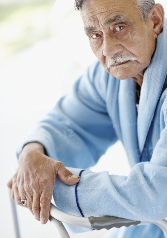 Elderly patient leaning on a walker. Photo : momentimages