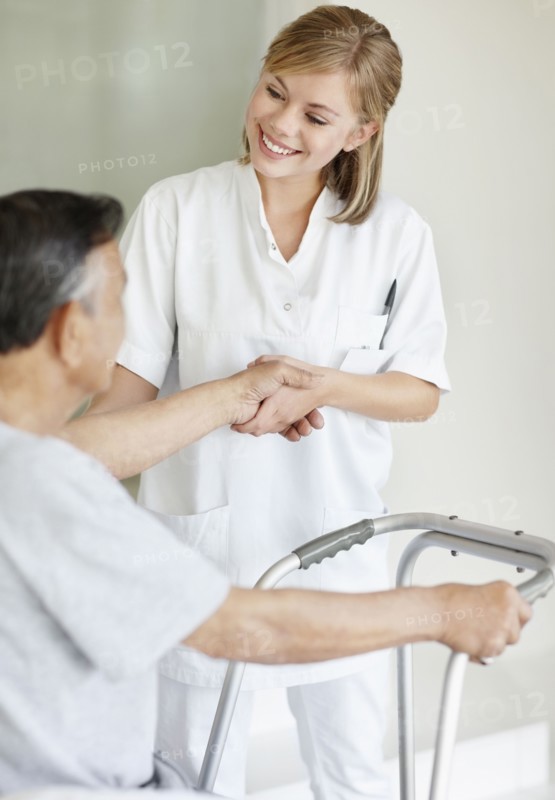 Nurse assisting patient with a walker. Photo : momentimages