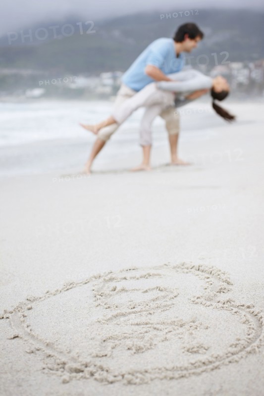 Playful couple at the beach. Photo : momentimages