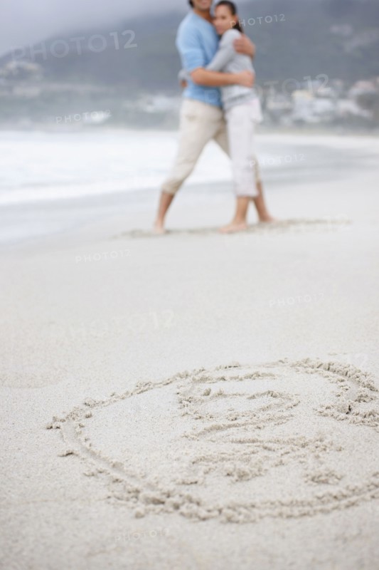 Couple embracing at the beach. Photo. momentimages