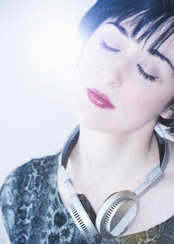 Relaxed woman with headphones around her neck. Photo. Daniel Grill