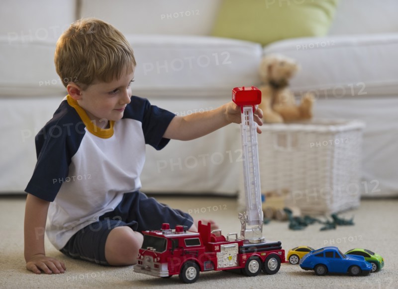 Young boy playing with toy fire truck. Photo. Daniel Grill