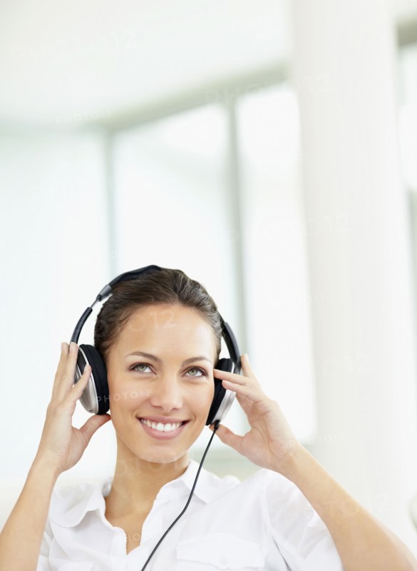 Woman listening to music on headphones. Photo. momentimages
