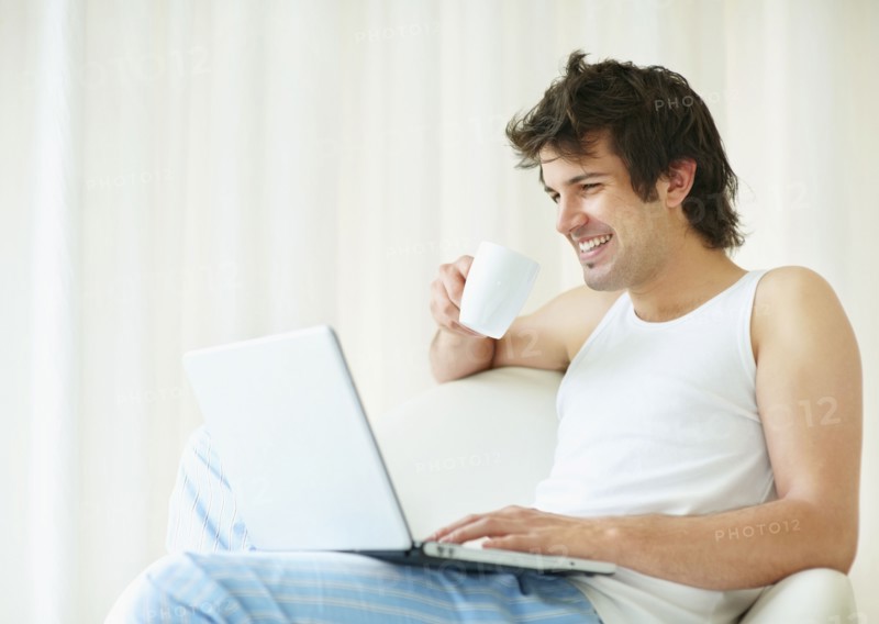Relaxed man browsing the internet. Photo. momentimages