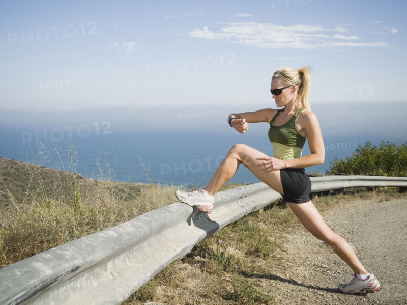 Runner stretching on the side of the road. Photo. Erik Isakson