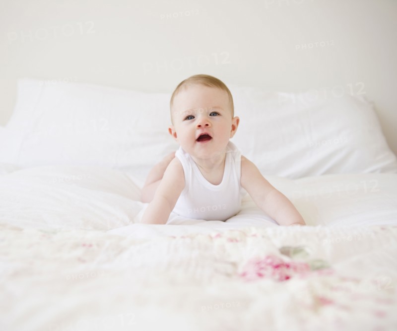 Baby on bed. Photo. Jamie Grill