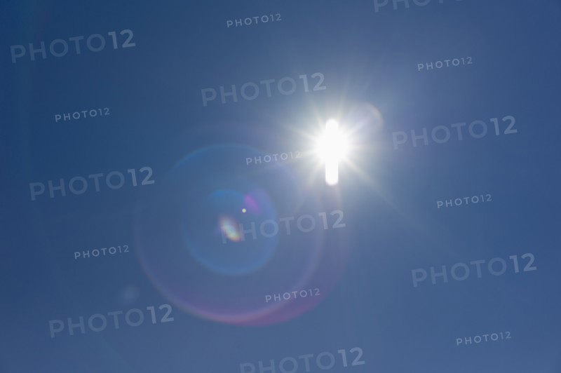 Flare of light in blue sky.