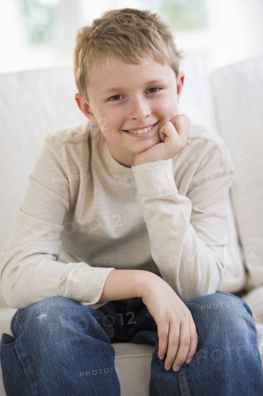 Young boy sitting on couch.