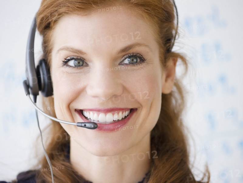 Cheerful businesswoman wearing headset. Photo. Jamie Grill